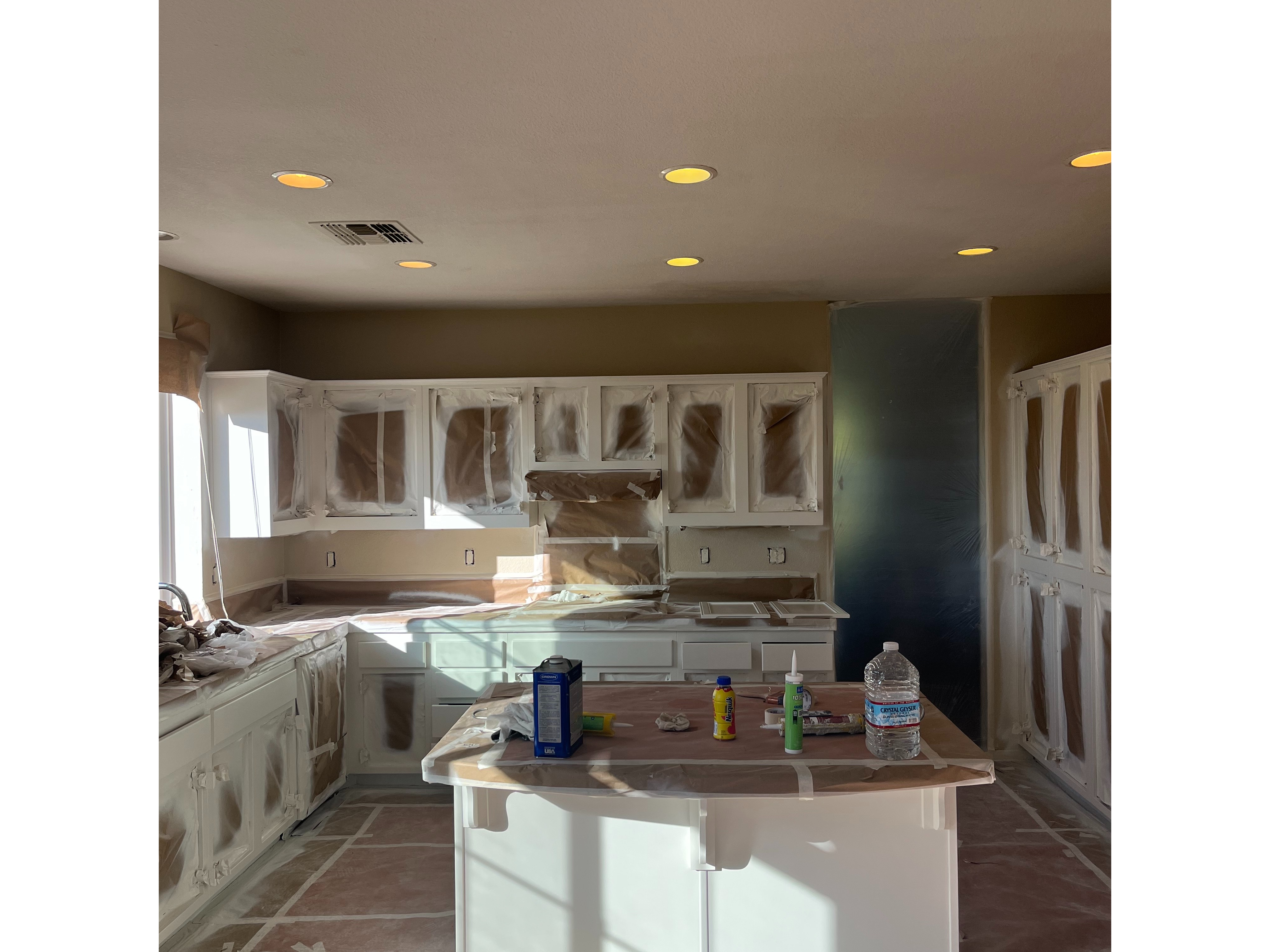 A Kitchen Scene Showing Cabinets and Countertops Wrapped in Plastic 3