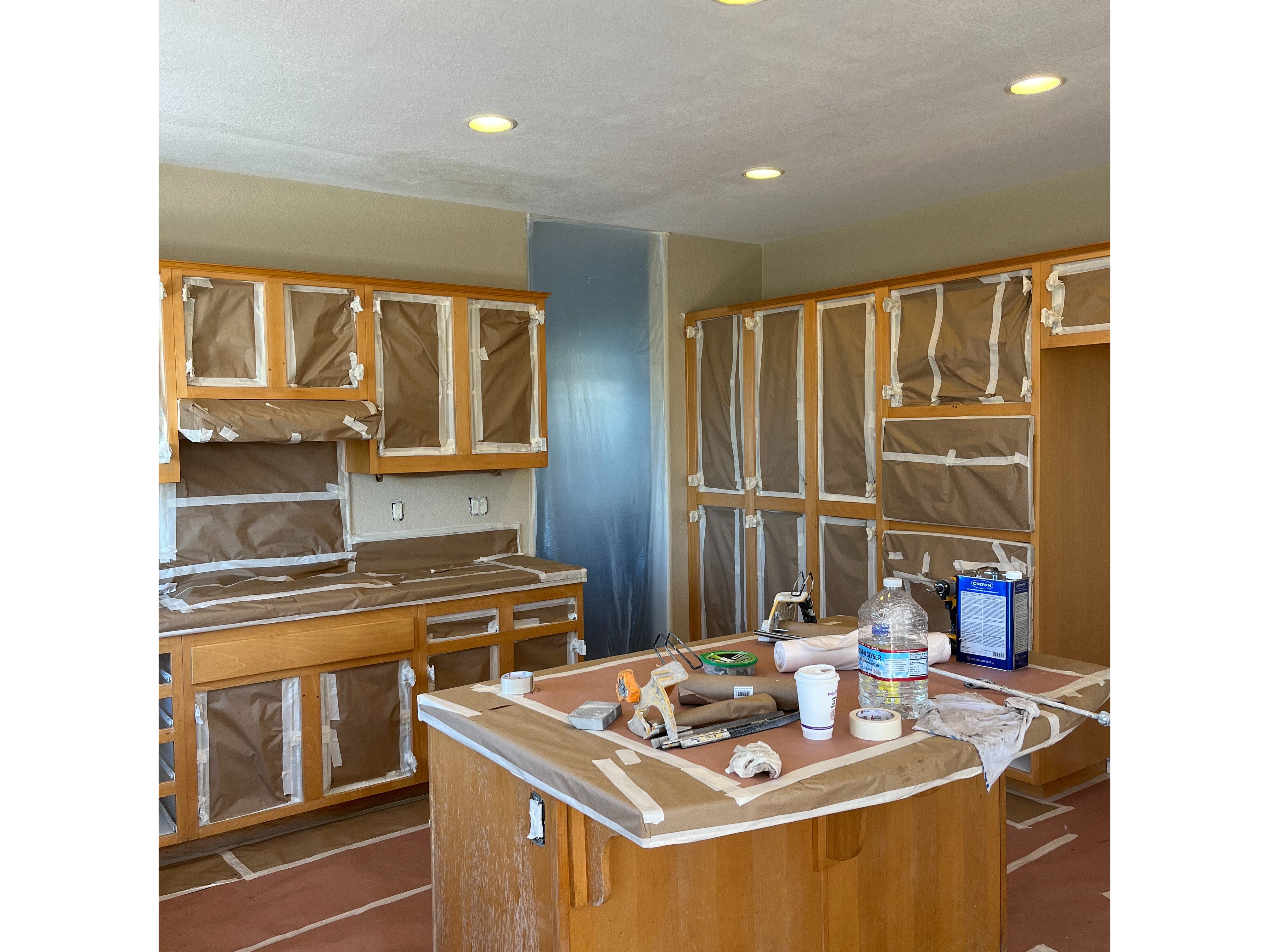 A Kitchen Scene Showing Cabinets and Countertops Wrapped in Plastic 2